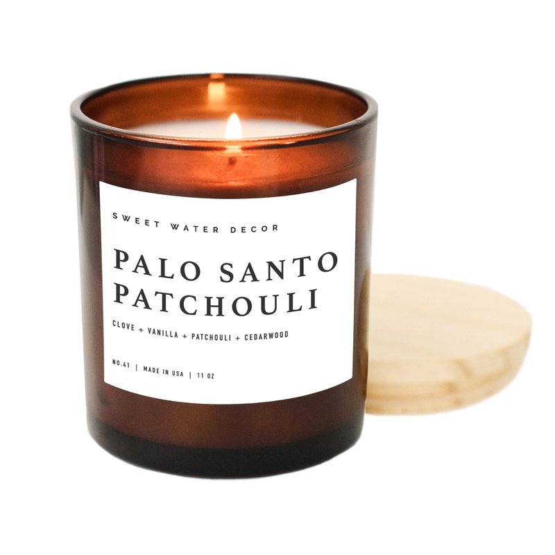 Sweet Water Decor Palo Santo Patchouli Soy Candle | 11 oz Amber Jar Candle In Brown